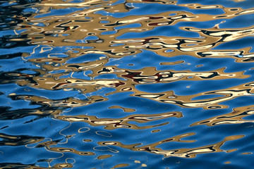 Fototapeta na wymiar Golden reflections on the sea surface at sunset. Selective focus.