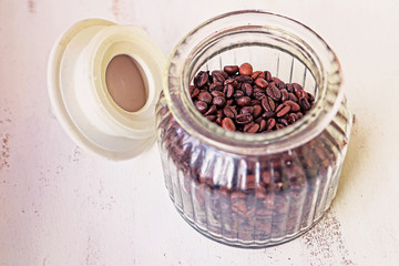 Roasted coffee grains in glass vase on the kitchen table