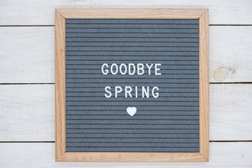 English text goodbye spring on a letter Board in white letters on a gray background and a symbol of heart
