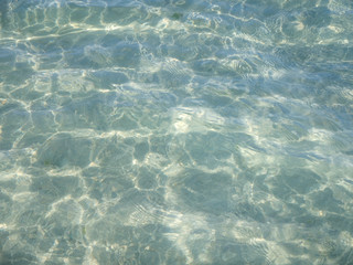 Obraz premium clear water with shadows from the waves in the sand