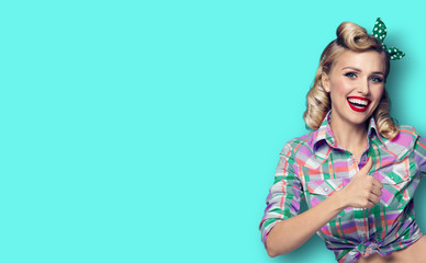 Photo of happy smiling woman, showing thumb up gesture, dressed in pin-up style, over green...