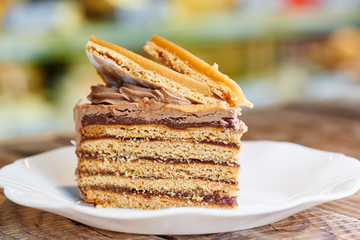 Homemade puffed caramel honey cake on white plate. Photo of holiday dessert for menu of confectionery restaurant