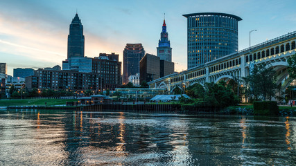 Small City Urban Skyline Of Cleveland Ohio At Sunrise Along The Cuyahoga River With Iconic Bridge.