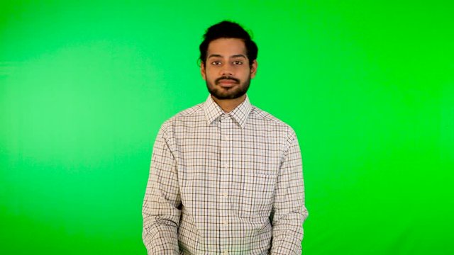 guy using mobile / tablet with green screen and green background 
indian guy with green screen