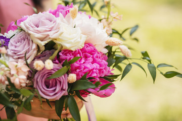 Beautiful wedding bouquet in bride's hands. Modern bouquet of different flowers.