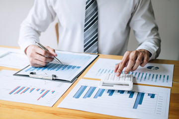 Businessman accountant working analyzing and calculating expense financial annual financial report balance sheet statement and analyze document graph and diagram, doing finance making notes on report
