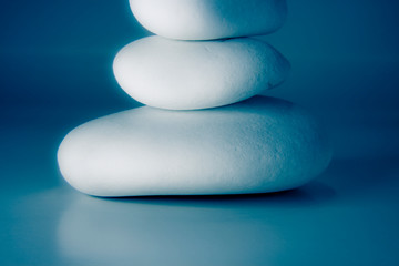 White stones stacked against a blue background - blurred and toned image