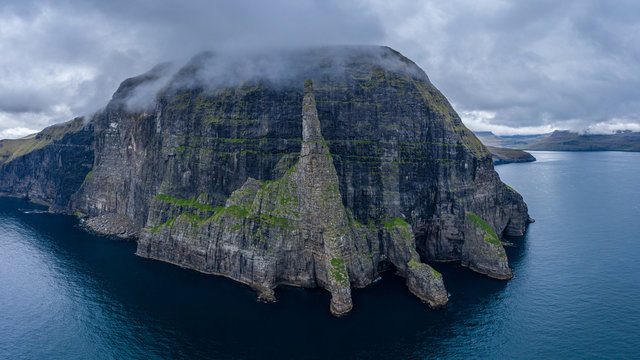 Aerial view of Trollkonufingur, Witch's Finger, Fjord under the clouds in Vagar, Faroe Islands