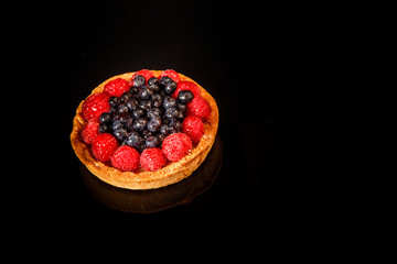 top view on tasty shortbread mini tart with custard and berries