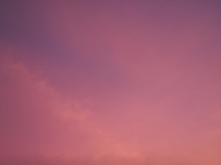 Twilight cloudy sky background, view of cloudy sky painted with red sun light after sunset.