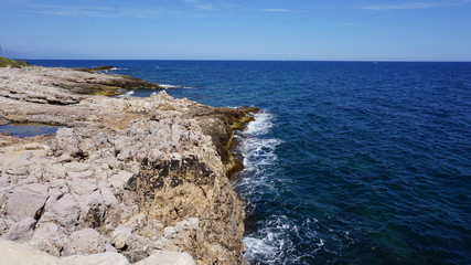 Küste am Meer mit Wellen, raue See, Felsen, blaues Wasser, mediterran