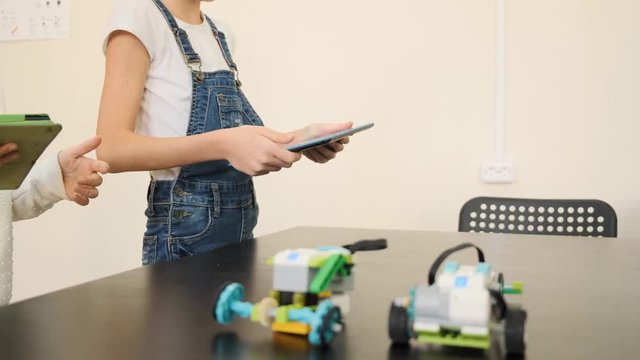 Two young girls control the electronacal car's moving at the e-learning class slow motion