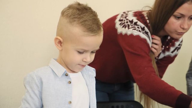 Nice female teacher in the red sweater explains to the young students how to work with electronic toys slow motion