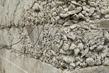 Concrete wall with gravel. Gray foundation of the house.