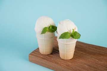 Fototapeta na wymiar Vanilla, cream ice cream in a waffle Cup on a blue background. Copy space. Horizontal photo.