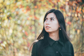 Female beauty portrait surrounded by vivid foliage. Dreamy beautiful girl with long natural black...