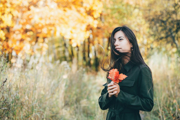 Female beauty portrait surrounded by vivid foliage. Dreamy beautiful girl with long natural black...