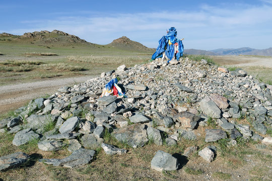 Western Mongolia steppe landscape. Ovoo, oboo, or obo (sacred stone heap) on the mountain pass in outskirts of Bayan-Ulgii town. Bayan-Ulgii Province, Mongolia..