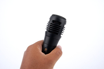 Fototapeta na wymiar Man's hand holding hand holding black microphone on a white background. close up