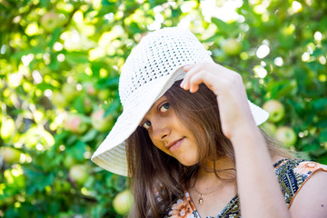 Portrait of a beautiful smiling girl. Happy girl in summer.  girl in the white hat. Girl in the garden. Summer girl closeup. Travel and Vacation. 