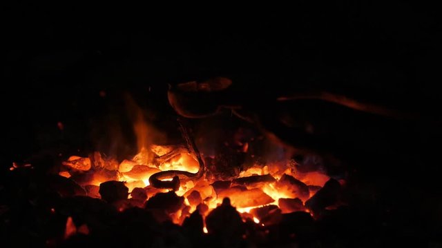 Flaming furnace fire with low red and yellow tongues in a Ukrainian smithy 