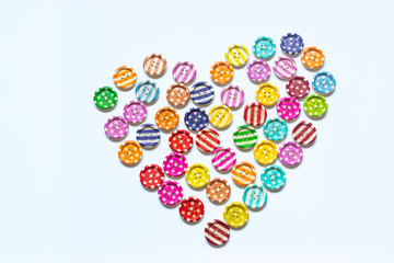 Various sewing buttons making a heart  isolated on white background