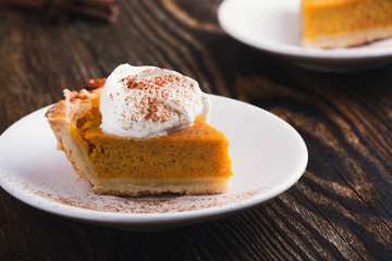 Slices of pumpkin pie with whipped cream, Thanksgiving day dessert