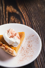 Obraz na płótnie Canvas Slices of pumpkin pie with whipped cream, Thanksgiving day dessert