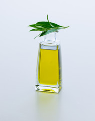 Carafe with olive oil and olive twig from olive tree. Isolated on white