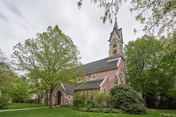 Beautiful and old Evangelical church surrounded by green bushes and trees in the European country, Baden Baden, Germany