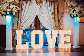 Wooden glowing love text letters. Rustic wedding dance floor lamp. - obrazy, fototapety, plakaty