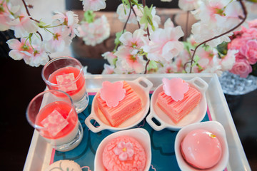 Sweet pastel peach and pink colorful set of afternoon tea in Sakura or Cherry Blossom theme. Tasty and delicious dessert, chocolate, bakery and pastry. Good for high tea party or Birthday celebration.