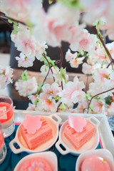 Sweet pastel peach and pink colorful set of afternoon tea in Sakura or Cherry Blossom theme. Tasty and delicious dessert, chocolate, bakery and pastry. Good for high tea party or Birthday celebration.