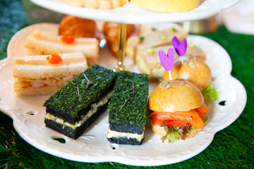 Magical and colorful set of afternoon tea in Alice in Wonderland theme. Tasty and delicious dessert, savories, bakery and pastry. Good for high tea party or Birthday celebration. Natural light.