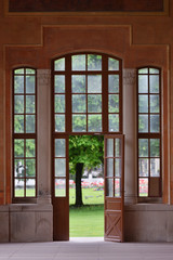 Beautiful and old large full-wall glass window with a door and access to the garden. European architecture