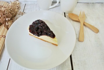 Blueberry cheesecake in a white plate on a vintage white wooden table.