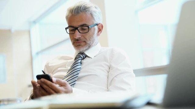 Relaxed businessman on cellphone in office