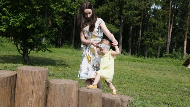considerate mother carries child hands walking on stumps
