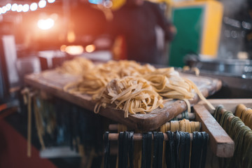 traditional italian black and yellow raw pasta on food festival