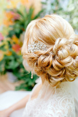 Fototapeta premium Bride hairstyle, bride dress up at home in a pink robe