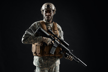 African male soldier wearing army uniform holding weapon.