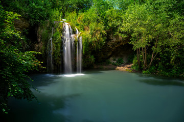 Fototapeta na wymiar Waterfall and a beautiful lagoon lake for relaxing in the summer forest.