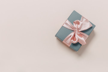 beautiful gift boxes wrapped in paper with gold and pink ribbon on a beige surface. Top view