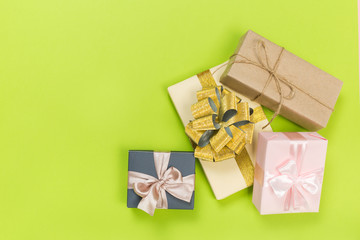 Gift box wrapped in pastel  paper with pink ribbon on green surface. Top view  with copy space.