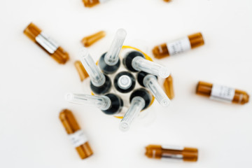 Plastic syringes with used ampoules on a white background, close-up shot, top view
