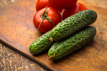 Fresh vegetables cucumbers and tomatoes on the kitchen table. Fresh harvest. Copy space