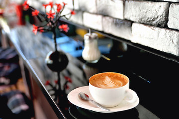 a cup of coffee is on the table in a cafe summer morning