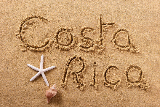 Costa Rica word written in sand on a sunny summer beach with starfish holiday vacation travel destination sign writing message photo