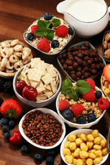 Cereal. Bowls of various cereals, berries and milk for breakfast. Muesli with kids cereals.