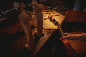 A violin being assembled on a wooden table